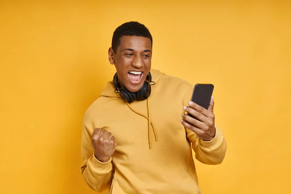 Excited Mixed Race Man Headphones Using Smart Phone While Standing — Stock Photo, Image