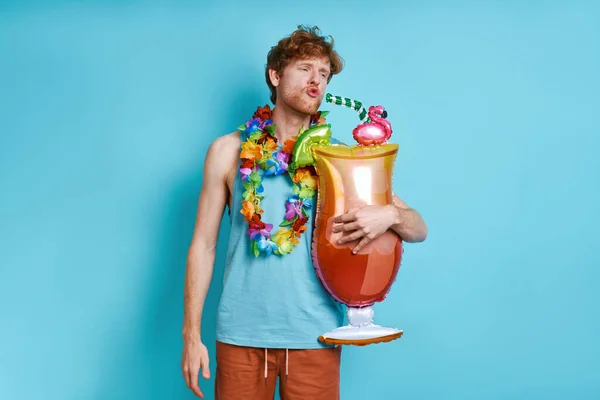 Playful Man Hawaiian Necklace Carrying Cocktail Shaped Balloon Blue Background — Stock Photo, Image