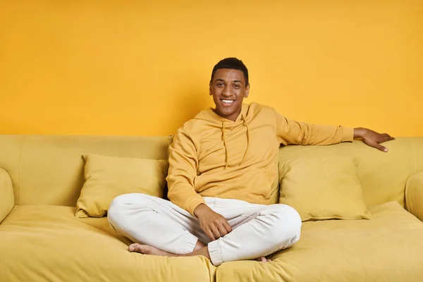 Feliz Hombre Raza Mixta Relajándose Sofá Con Fondo Amarillo —  Fotos de Stock