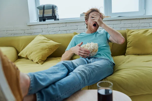 Terkejut Pemuda Menonton Film Seram Sambil Duduk Sofa Rumah — Stok Foto