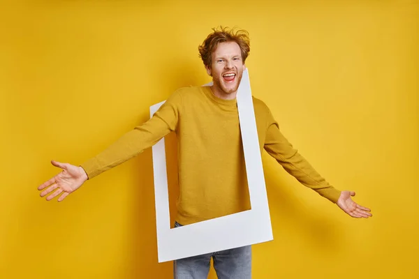 Playful Man Carrying Picture Frame Shoulder While Standing Yellow Background — Stock Photo, Image