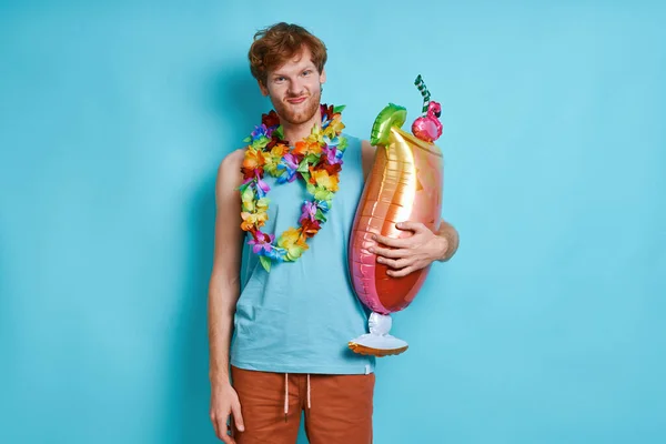 Bored Man Hawaiian Necklace Carrying Cocktail Shaped Balloon Blue Background — Stock Photo, Image