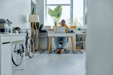 Ofiste çalışan neşeli, genç bir Afrikalı.