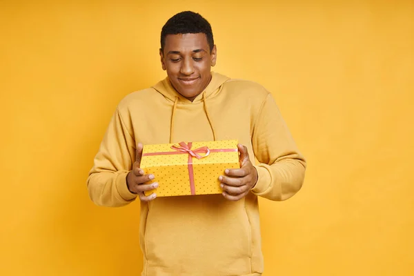 Surprised African Man Holding Gift Box While Standing Yellow Background — Stockfoto