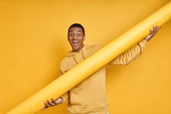 Happy African Man Carrying Rolled Yellow Wallpaper While Standing Yellow — Stock Photo, Image