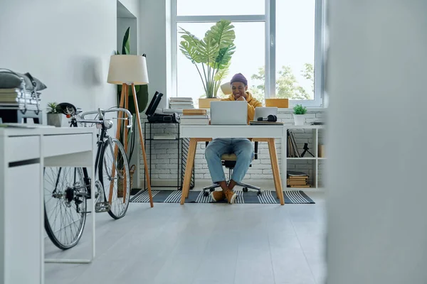 Ofiste çalışan neşeli, genç bir Afrikalı.