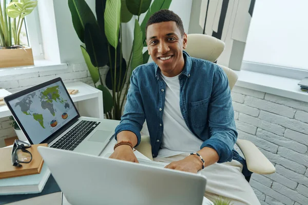在办公室工作时使用笔记本电脑的快乐非洲男人的头像 — 图库照片