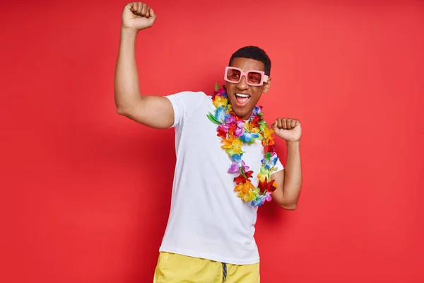 Przystojny Młody Mężczyzna Hawajskim Naszyjniku Tańczący Czerwonym Tle — Zdjęcie stockowe