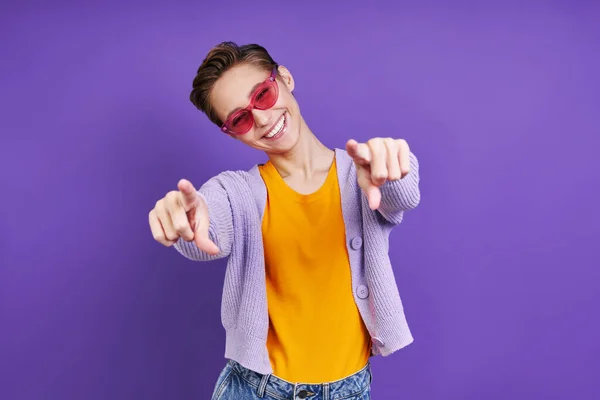 Jovem Alegre Apontando Câmera Enquanto Está Contra Fundo Roxo — Fotografia de Stock