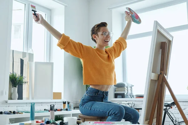 Mujer Joven Feliz Llevando Paleta Artista Pincel Mientras Dibuja Estudio —  Fotos de Stock