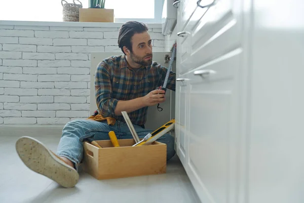 Confident Young Plumber Repairing Sink Domestic Kitchen — Foto Stock