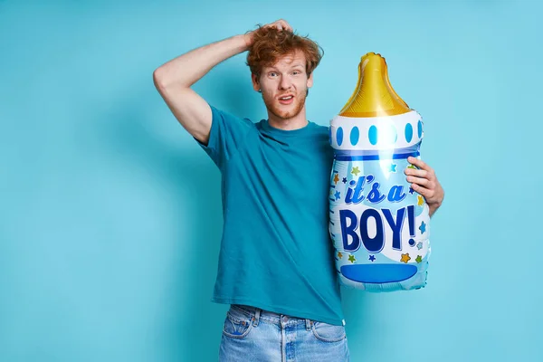 Surprised Redhead Man Holding Baby Bottle Shaped Balloon While Standing — ストック写真