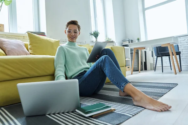 Hermosa Mujer Joven Usando Tecnologías Mientras Está Sentada Suelo Casa —  Fotos de Stock