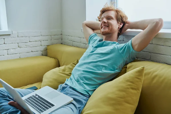 Cheerful Redhead Man Using Laptop Holding Hands Head While Sitting — Foto de Stock