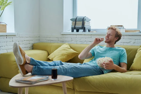 Happy Young Man Enjoying Snacks While Sitting Couch Home — Stock Photo, Image