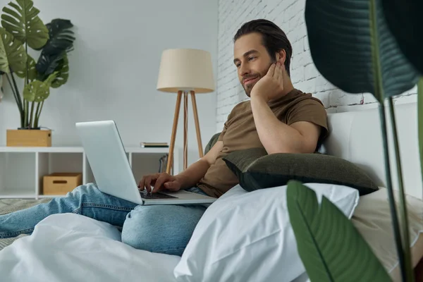 Handsome Young Man Working Laptop While Sitting Bed Home — Foto de Stock