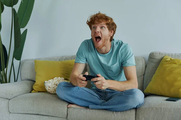 Cheerful Redhead Man Using Controller While Playing Video Games Couch — Stok fotoğraf