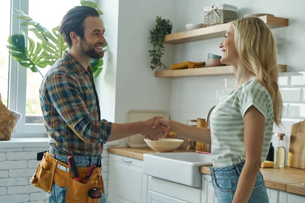 Beautiful Young Woman Shaking Hand Male Plumber While Standing Kitchen — Stockfoto