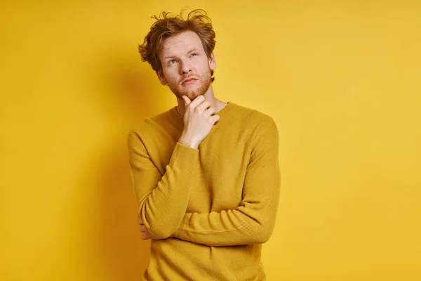 Thoughtful Redhead Man Holding Hand Chin While Standing Yellow Background — Foto Stock