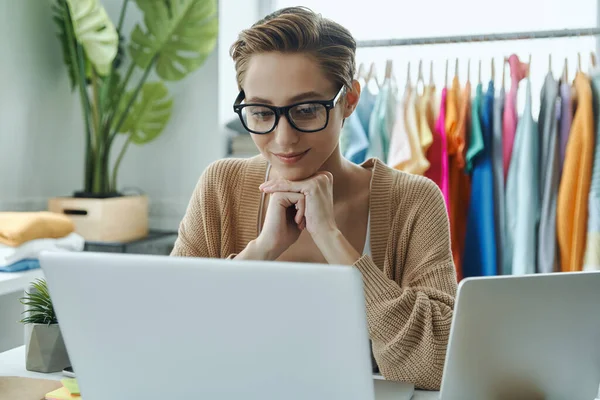 Concentrated Young Woman Looking Laptop While Working Fashion Store Office — Photo