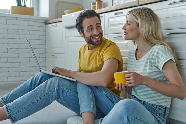 Casal Feliz Usando Laptop Enquanto Sentado Chão Inclinado Balcão Cozinha — Fotografia de Stock