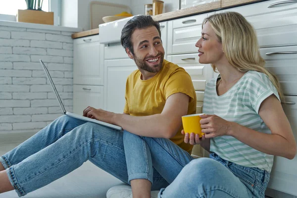 Pareja Feliz Usando Ordenador Portátil Mientras Está Sentado Suelo Apoyado —  Fotos de Stock