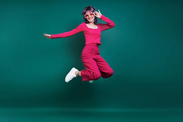 Χαρούμενη Νεαρή Γυναίκα Πηδάει Πάνω Πράσινο Φόντο — Φωτογραφία Αρχείου