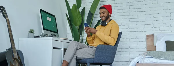 Happy Young African Man Using Smart Phone While Sitting His — Foto Stock