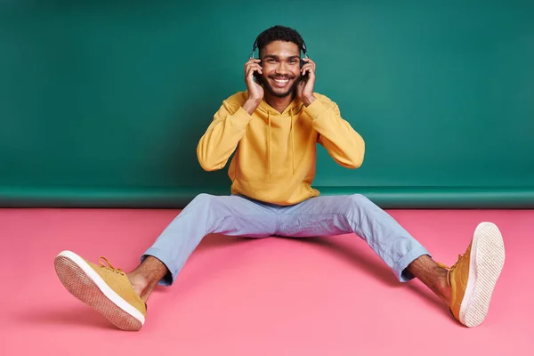 Relaxed African Man Headphones Enjoying Music While Sitting Colorful Background — Stockfoto