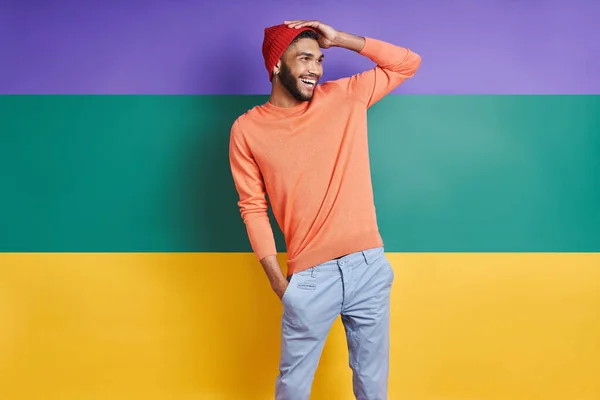 Handsome African Man Adjusting Hat Smiling While Standing Colorful Background — ストック写真