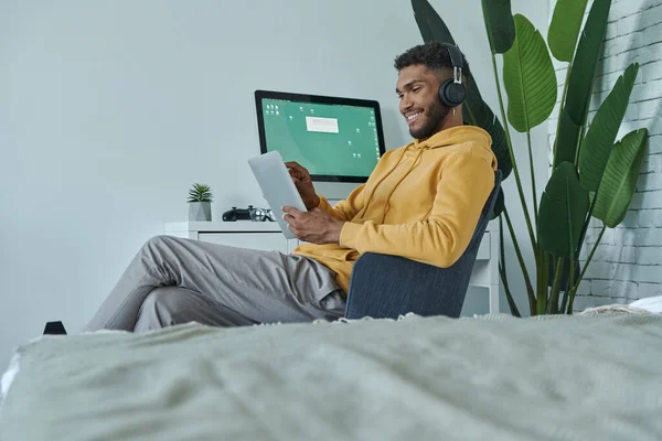 快乐的非洲男人坐在家里工作时使用数字平板电脑 — 图库照片