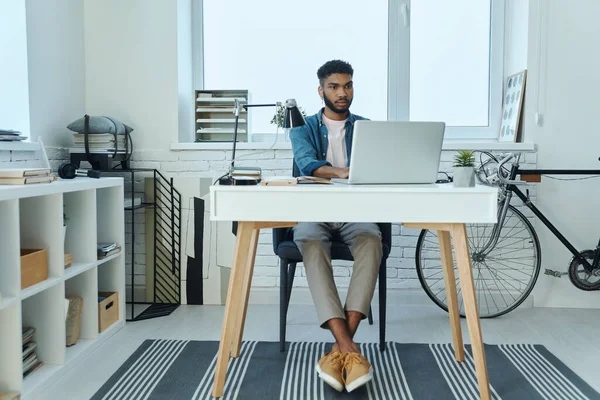 Hombre Africano Joven Concentrado Usando Ordenador Portátil Mientras Trabaja Oficina —  Fotos de Stock