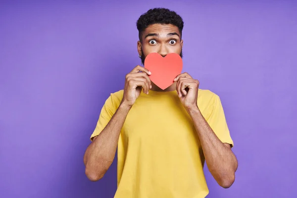 Playful African Man Covering His Eye Paper Heart While Standing — Stok fotoğraf