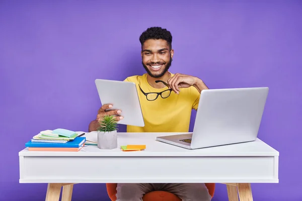 Homem Africano Feliz Usando Tablet Digital Enquanto Sentado Mesa Contra — Fotografia de Stock