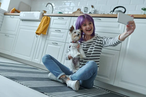 Happy Woman Carrying Little Dog Making Selfie While Sitting Floor — Stok fotoğraf