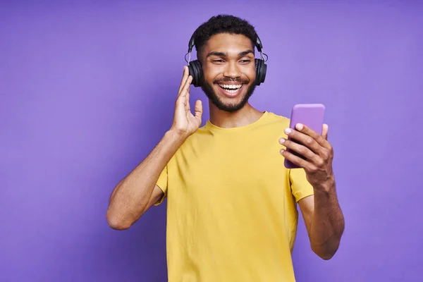 Bel Homme Africain Dans Casque Tenant Téléphone Intelligent Tout Écoutant — Photo