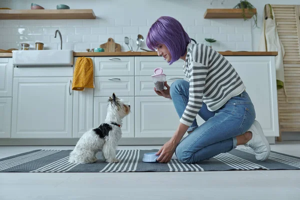 Genç Bir Kadın Mutfakta Köpeğine Yemek Veriyor — Stok fotoğraf