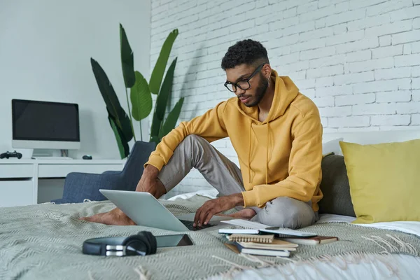 Confident African Man Using Laptop While Sitting Bed Home — Stock Fotó