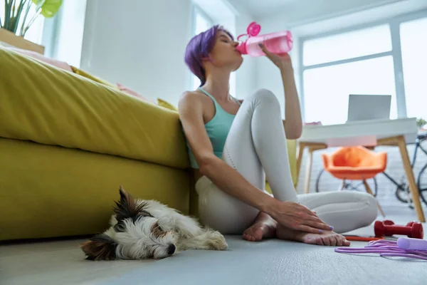 Relaxed Woman Sports Clothing Drinking Water Exercise Mat Home — Stock fotografie