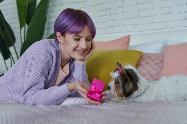 Happy Young Woman Holding Little Gift Box While Lying Bed — Stock Photo, Image