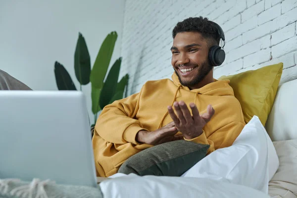 Happy African Man Headphones Looking Laptop While Lying Bed Home — Stockfoto