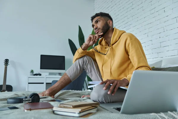 Young African Man Holding Note Pad Looking Thoughtful While Studying — Stock Fotó