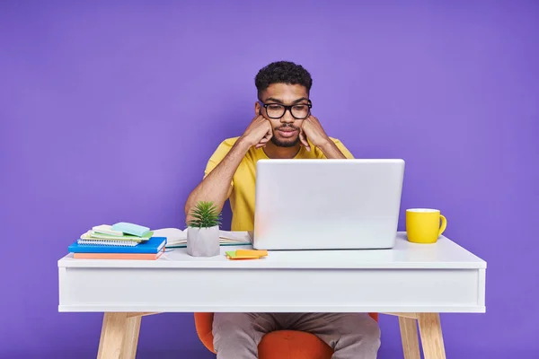 Frustrated African Man Looking Laptop While Sitting Desk Purple Background — Stockfoto