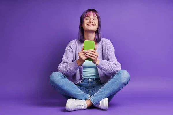 Beautiful Young Woman Holding Smart Phone Smiling While Sitting Purple — 스톡 사진
