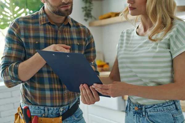 Close Confident Handyman Holding Clipboard While Woman Signing Documents — Stockfoto