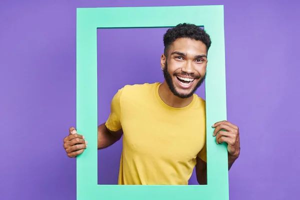 Happy African Man Looking Picture Frame While Standing Purple Background — 图库照片