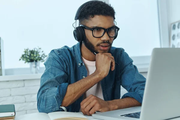 Concentrated Young African Man Headphones Looking His Laptop While Working — 图库照片