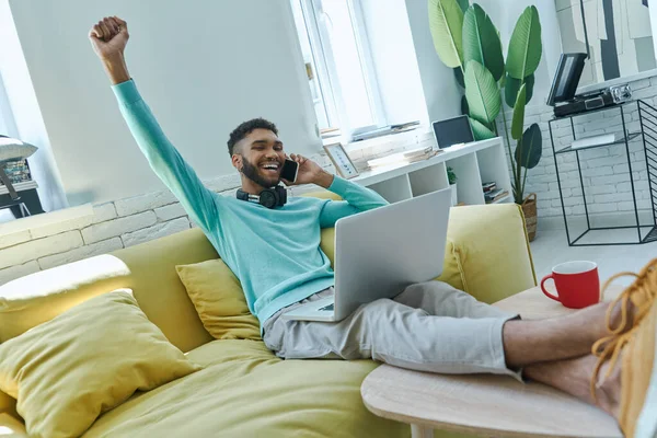 Happy African Man Talking Mobile Phone Gesturing While Sitting Couch — Foto Stock