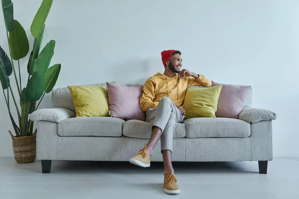 Handsome African Man Looking Thoughtful While Sitting Couch —  Fotos de Stock