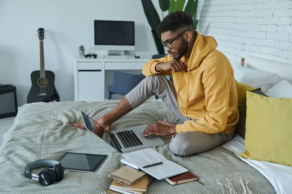 Confident African Man Using Laptop While Sitting Bed Home — 스톡 사진